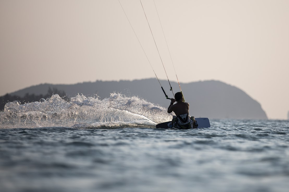 A person is in the water riding on a kneeboard.