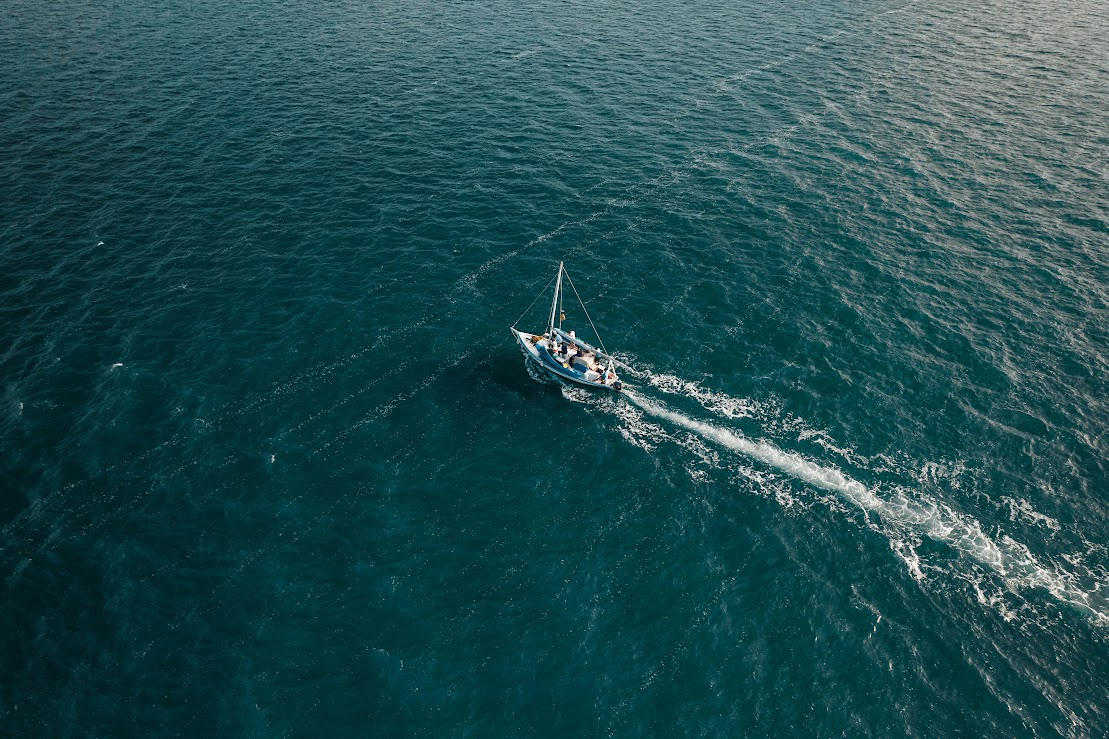 Overview of a boat driving into the middle of the ocean.
