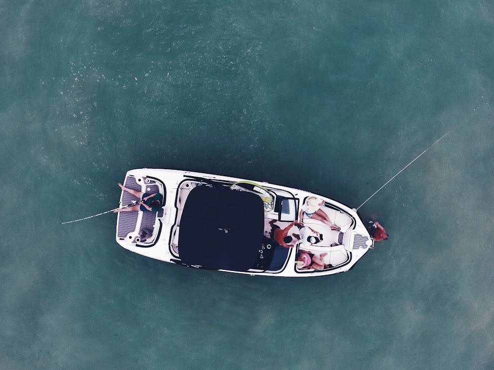Top view of a boat with people relaxing and fishing.