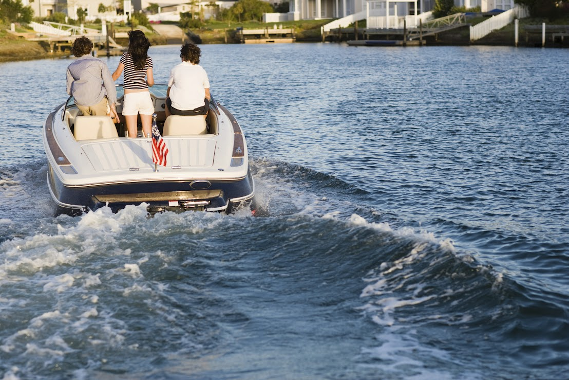 Three friends are riding a boat to the shore.