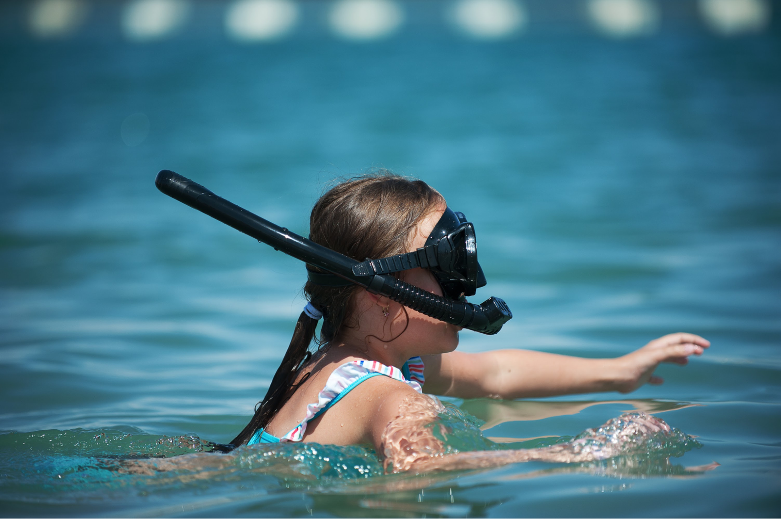 A young girl preparing to snorkel