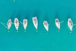 An aerial view of sail boats in the ocean