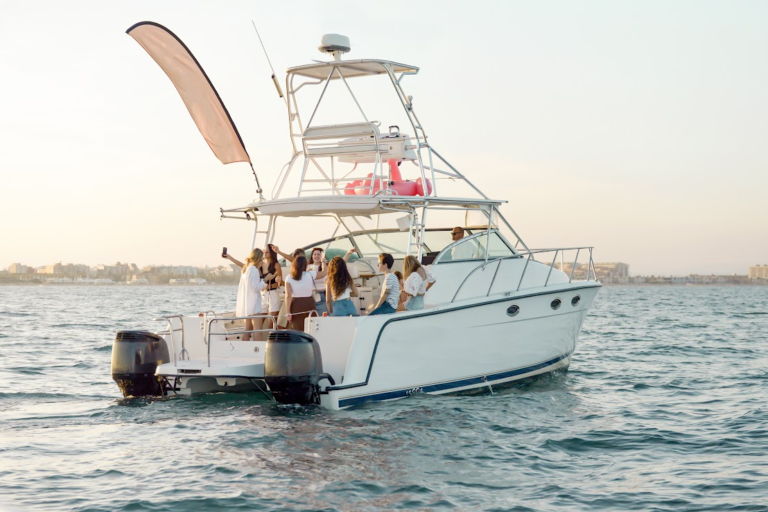 A group of young people having a good time on a boat in the water.