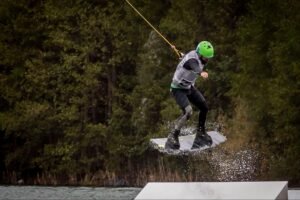Man performing a jump while wakeboarding on open water