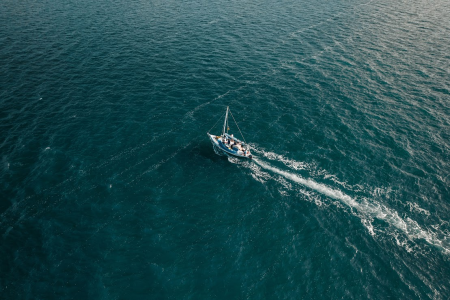 Overview of a boat driving into the middle of the ocean.